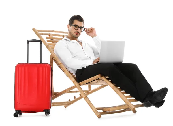 Fiatal üzletember laptoppal és bőröndon a nyugágyon a fehér háttér előtt. Strandtartozékok — Stock Fotó