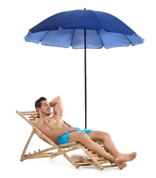 Jonge man op ligstoel onder paraplu tegen witte achtergrond. Strand accessoires — Stockfoto