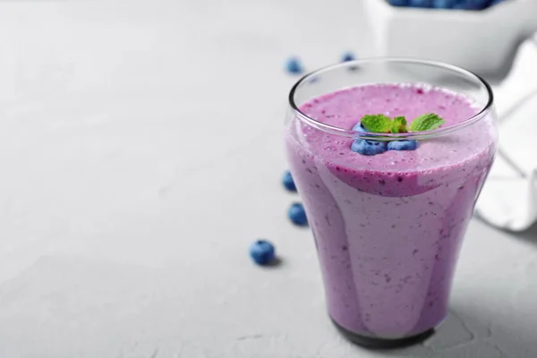 Pohár ízletes áfonyás smoothie a világosszürke asztalra. Szóköz a szöveghez — Stock Fotó