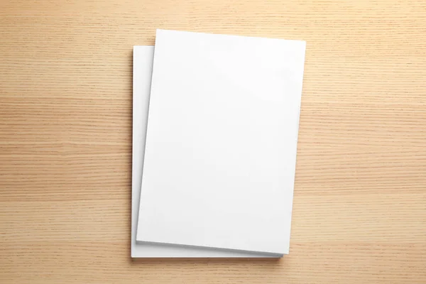 Üres papírlapok a fából készült háttér brosúrához, felülnézetben. Kigúnyolják — Stock Fotó