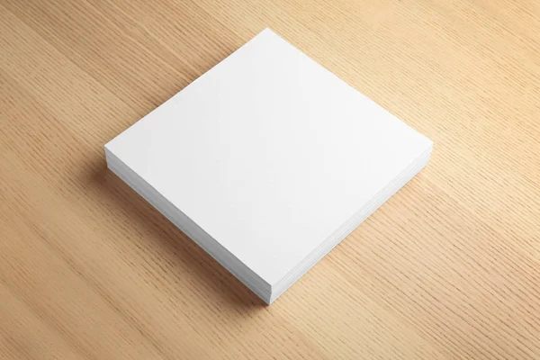 Stapel blanco papieren vellen voor brochure op houten achtergrond. Mock up — Stockfoto