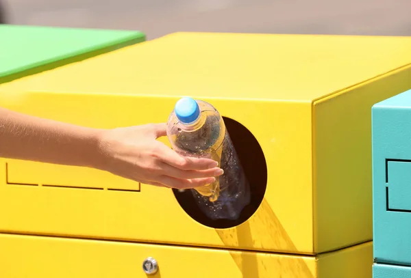 Vrouw gooien plastic fles in sorteren bin op City Street, close-up. Recycling afval — Stockfoto