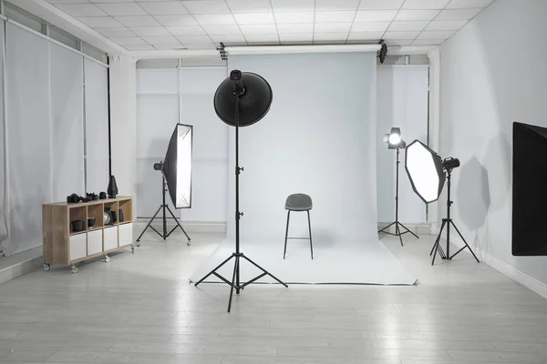 Fotoğrafçının stüdyosunda boş sandalye ve profesyonel ekipman — Stok fotoğraf