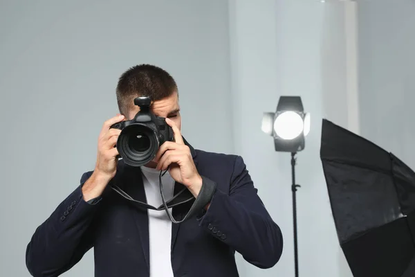 Fotógrafo profissional tirando fotos em estúdio moderno — Fotografia de Stock