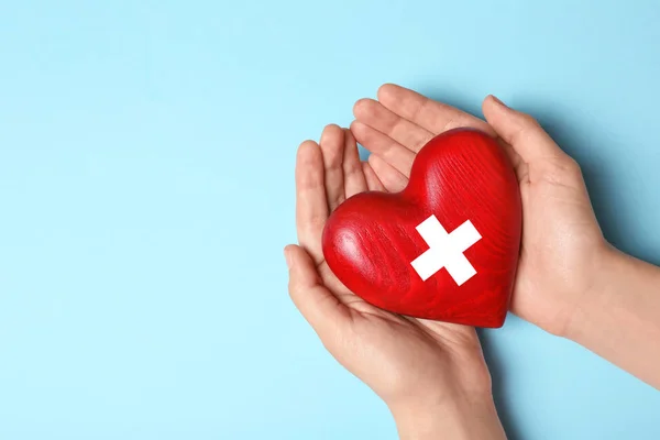 Mujer sosteniendo el corazón sobre fondo azul, vista superior con espacio para el texto. Concepto de donación —  Fotos de Stock