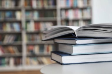 Kütüphanede beyaz tabloda kitap yığını