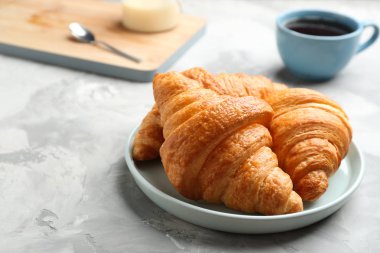 Gri masa üzerinde taze kruvasan plaka, metin için boşluk. Fransız pastası