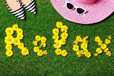 Yeşil çim üzerinde sarı çiçeklerin kelime Relax ile Düz yatıyordu kompozisyon