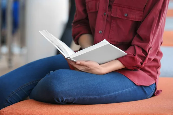 Ung kvinna läsa bok i biblioteket, närbild — Stockfoto
