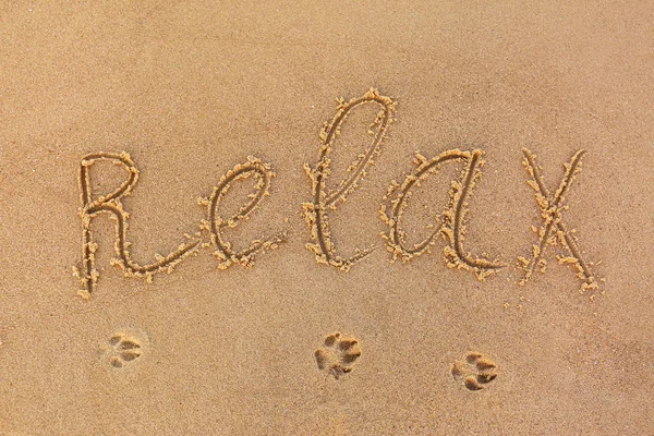 Слово "RELAX" написано на песчаном пляже, вид сверху — стоковое фото