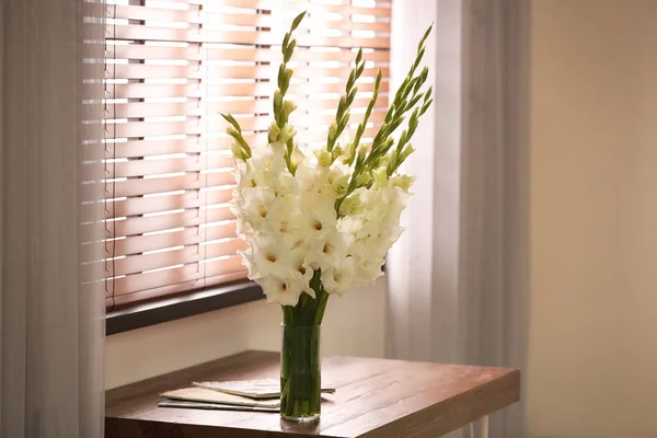 Vas dengan indah bunga gladiolus putih di atas meja kayu di kamar, ruang untuk teks — Stok Foto