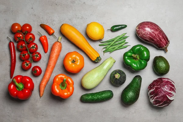 Composición plana de diferentes verduras frescas sobre una mesa gris — Foto de Stock