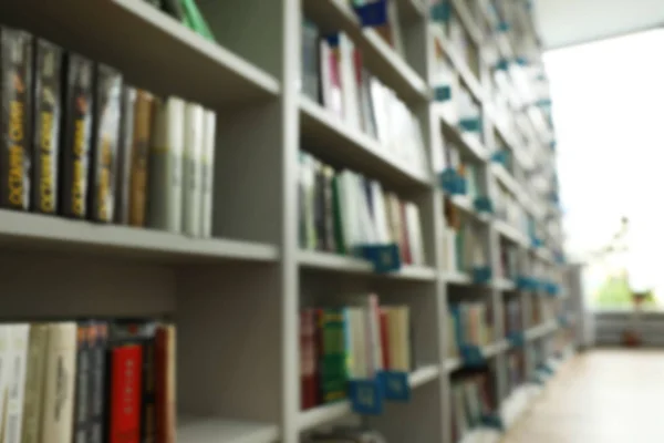 Vista turva das prateleiras com livros na biblioteca — Fotografia de Stock