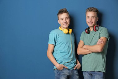 Renkli arka planda kulaklıklı genç ikiz kardeşler. Metin için alan