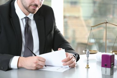 Male notary working with documents at table in office, closeup clipart