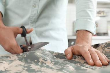 Atölye, çekim içinde makas ile profesyonel terzi kesme Kamuflaj kumaş