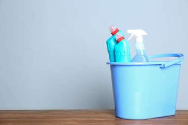 Renk arka plan karşı masada farklı temizlik ürünleri ile Plastik kova. Metin için alan