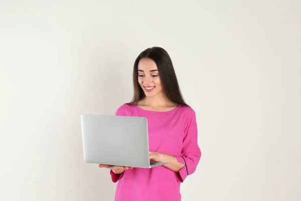 Retrato de mujer joven en traje casual con portátil sobre fondo claro — Foto de Stock