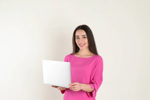 Portrait de jeune femme en tenue décontractée avec ordinateur portable sur fond clair — Photo