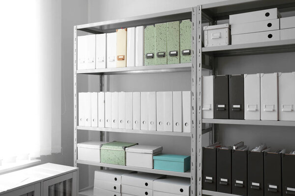 Folders with documents on shelves in archive