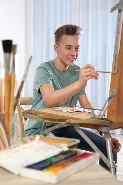 Adolescente pintura menino no cavalete na oficina. Clube de passatempos — Fotografia de Stock