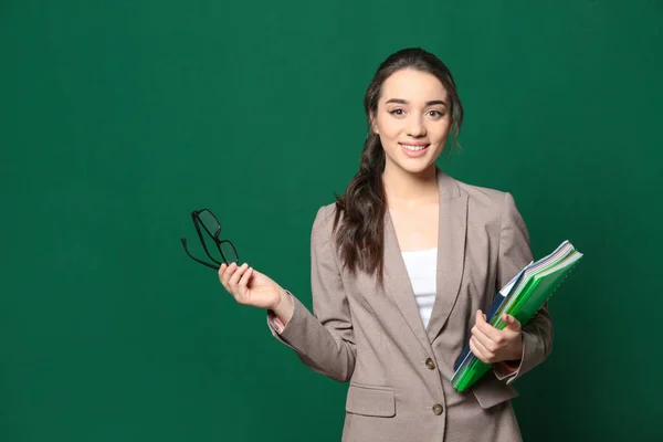 Ritratto di giovane insegnante con libri vicino alla lavagna, spazio per testo — Foto Stock