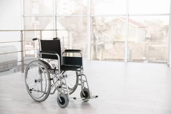 Moderna silla de ruedas en habitación vacía, espacio para texto. Equipos médicos — Foto de Stock