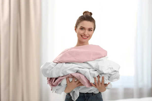 Vrouw Holding stapel vuile Wasserij binnenshuis — Stockfoto