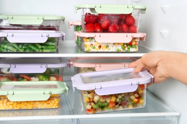 Mujer tomando caja con mezcla de verduras del refrigerador, primer plano — Foto de Stock