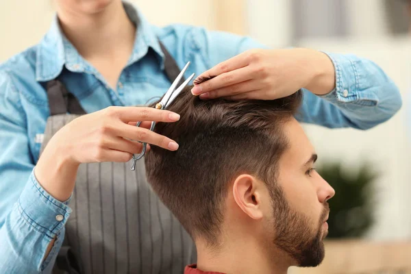 Barber making stylish haircut with professional scissors in beauty salon — Stock Photo, Image