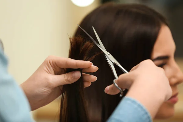 Barbeiro fazendo corte de cabelo elegante com tesoura profissional no salão de beleza, close-up — Fotografia de Stock