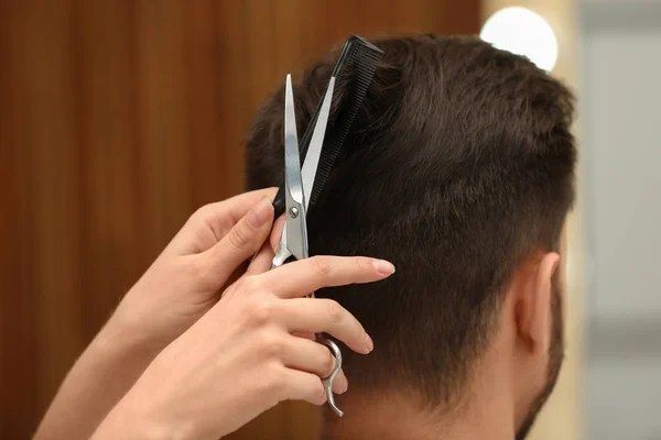 Barbeiro fazendo corte de cabelo elegante com tesoura profissional no salão de beleza, close-up — Fotografia de Stock