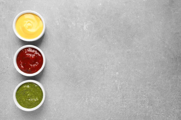 Ensemble de différentes délicieuses sauces sur table grise, vue sur le dessus. Espace pour le texte — Photo