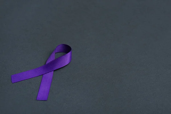 Purple awareness ribbon on black background, space for text