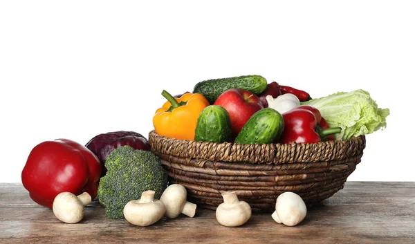 Tigela de vime com variedade de legumes e frutas deliciosos frescos na mesa contra fundo branco — Fotografia de Stock