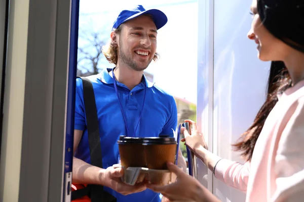 Donna che riceve ordini dal corriere alla porta. Servizio di consegna cibo — Foto Stock