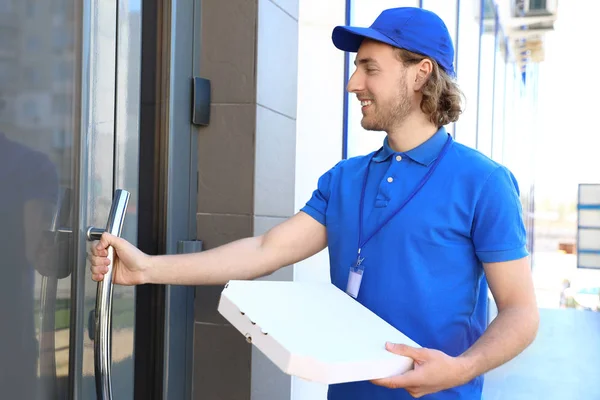 Mužské kurýr s pizzou u vchodu. Služby doručování potravin — Stock fotografie