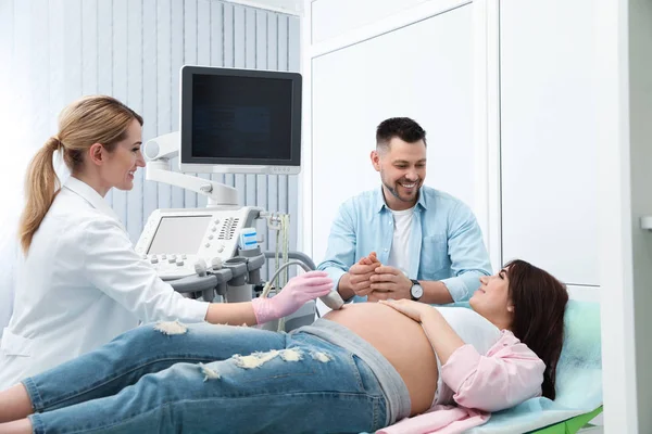 Muž podporující svou ženu během ultrazvukového scanu na klinice — Stock fotografie