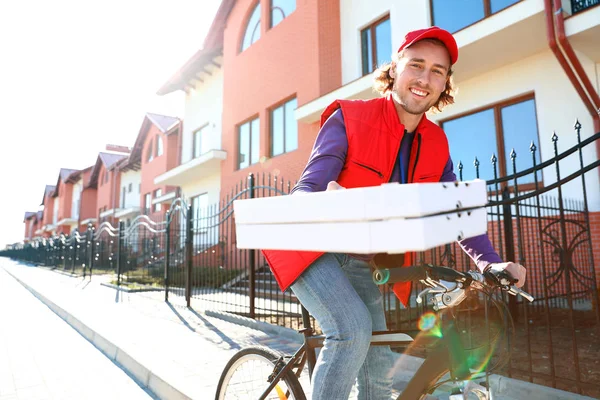 Courrier masculin à vélo livrant de la nourriture en ville — Photo