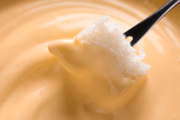 Mergulhando pão em fondue de queijo saboroso, close-up — Fotografia de Stock