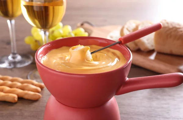 Kruka med utsökt ostfondue och bröd på bordet — Stockfoto