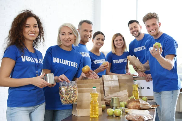 Equipo de voluntarios recogiendo donaciones de alimentos en interiores — Foto de Stock