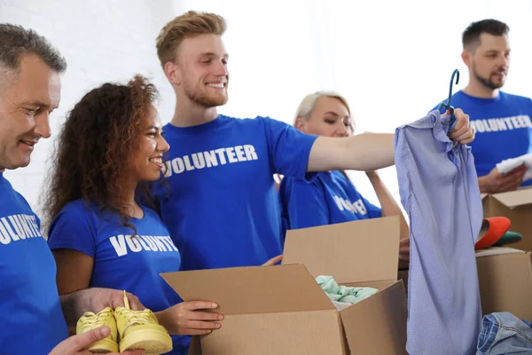 Equipo de voluntarios recogiendo donaciones en cajas interiores — Foto de Stock
