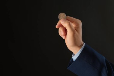 Siyah arka planda bozuk para tutan genç adam, yakın çekim. Metin için alan