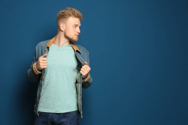 Mavi arka planda boş t-shirt giyen genç adam. Tasarım için mockup