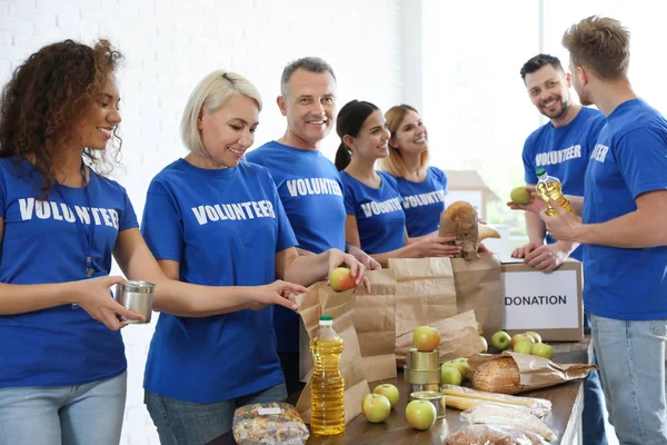 Equipo de voluntarios recogiendo donaciones de alimentos en interiores — Foto de Stock