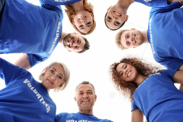 Equipo de voluntarios se unió en círculo sobre fondo claro, vista inferior — Foto de Stock