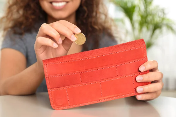 Γυναίκα βάζοντας το κέρμα στο πορτοφόλι στο τραπέζι, κοντινό πλάνο — Φωτογραφία Αρχείου
