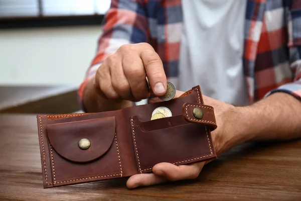 Ανώτερος άνθρωπος βάζοντας κέρματα σε τσάντα στο τραπέζι, κοντινό πλάνο — Φωτογραφία Αρχείου