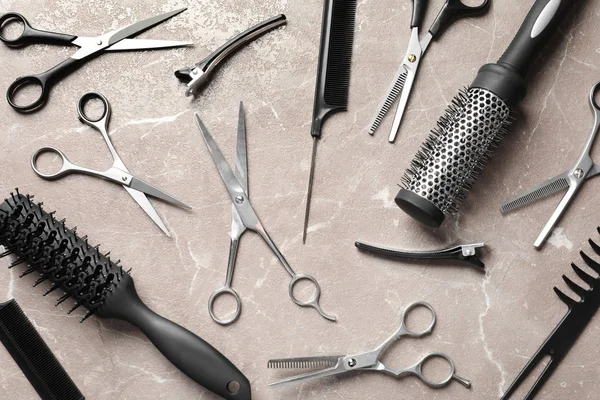 Flat composition with hairdresser's accessories and scissors on brown marble background — Stock Photo, Image